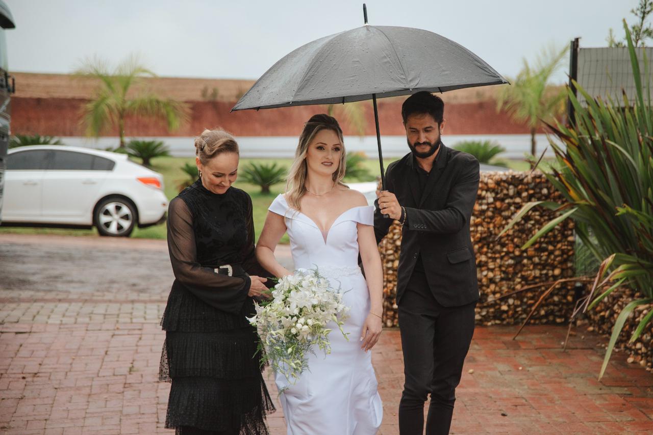 Cerimonialista acompanhando a noiva sob guarda-chuva